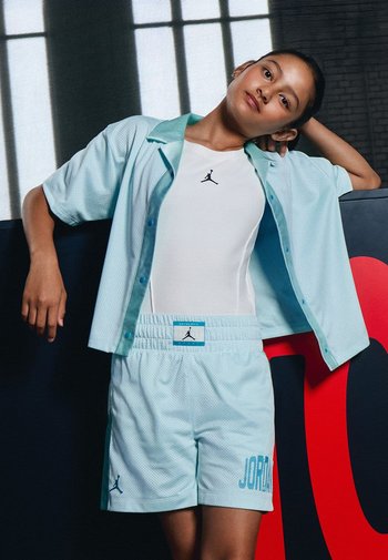Helles blaues Netz-T-Shirt mit kurzen Ärmeln und Kragen, weiße enganliegende Tanktop und passende Shorts mit "JORDAN" in Blau am Saum bedruckt.