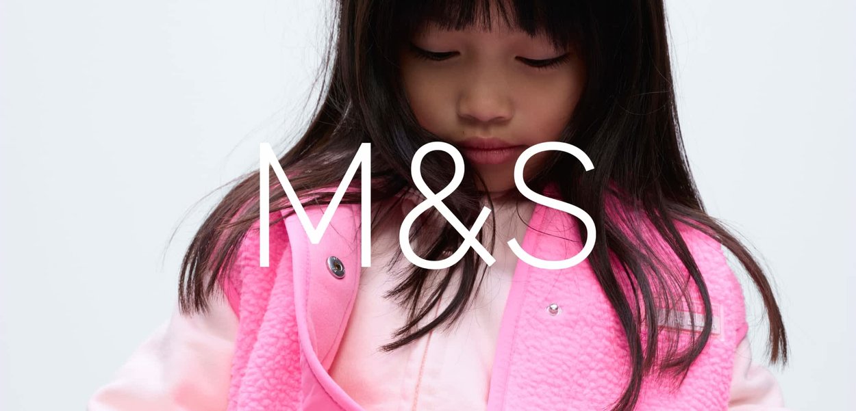 Veste sans manches en polaire rose vif avec une surface texturée, portée sur un sweat-shirt rose clair. La veste est dotée de fermetures à boutons-pression et d'une coupe décontractée.