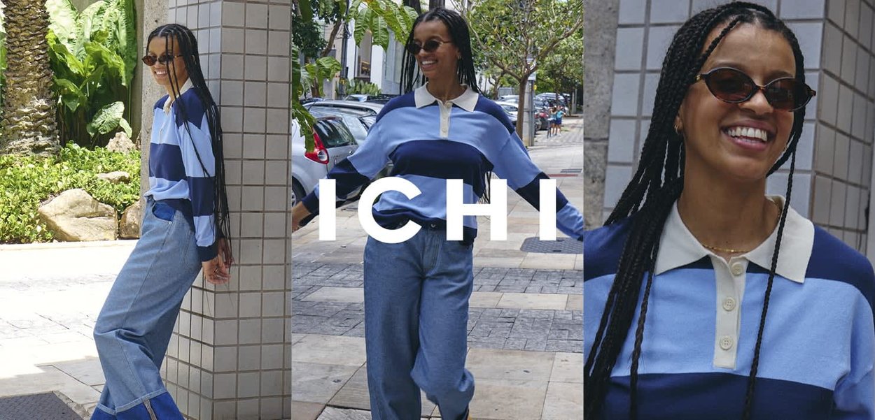 Frau mit langen Zöpfen, die Sonnenbrillen trägt, ein blau gestreiftes Polohemd und Jeans mit weitem Bein, posiert im Freien auf einer sonnigen Straße.