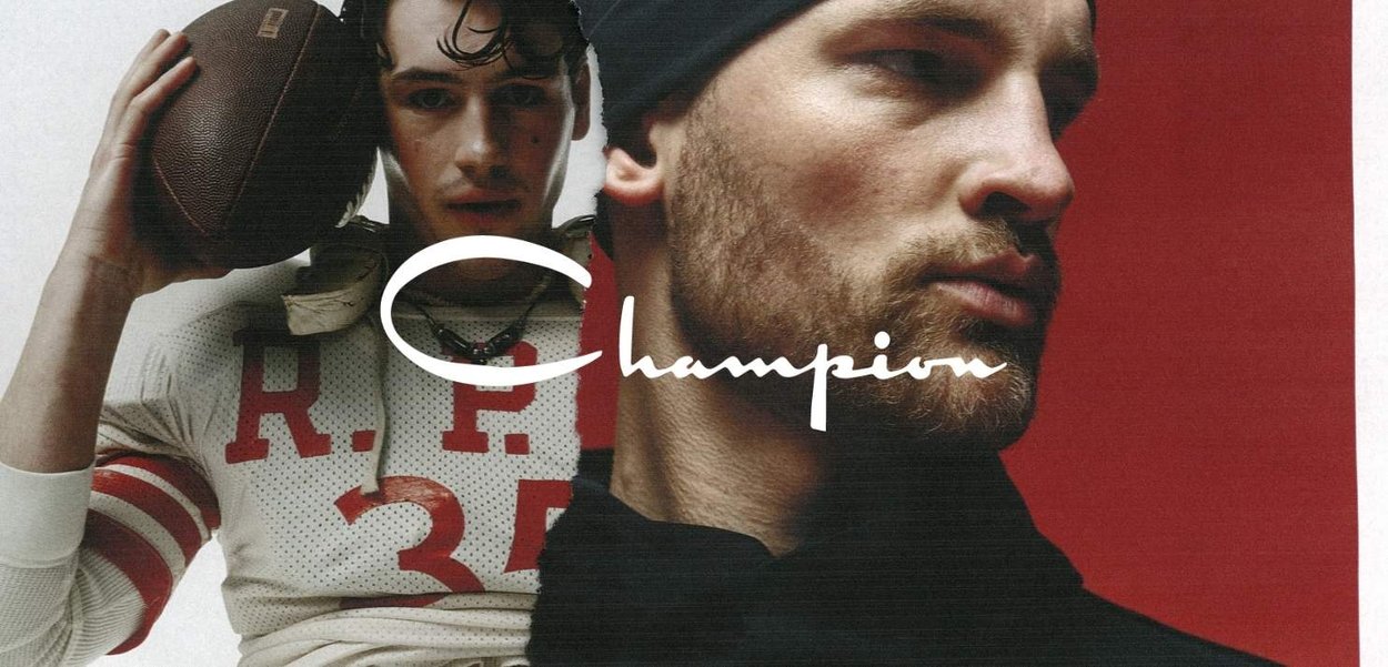 Due uomini, uno che tiene un pallone da football con una maglia retrò, l'altro con abiti scuri e un berretto, su uno sfondo rosso.