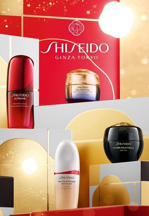 Shiseido huidverzorgingsproducten in verschillende vormen: een rode serumfles, een gouden crèmepot, een witte foundationfles en een zwarte nachtcrème.