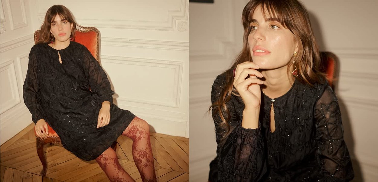 Svart klänning med texturerat tyg, långärmad och rund nyckelhålsringning. Dekorerad med pärlor och transparenta detaljer, matchad med mönstrade strumpbyxor.