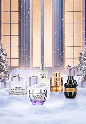 Five beauty products arranged on snowy surface: Kiehl's cream, Lancôme cream, Armani Acqua di Gio, Azzaro fragrance, and Viktor & Rolf Spicebomb.