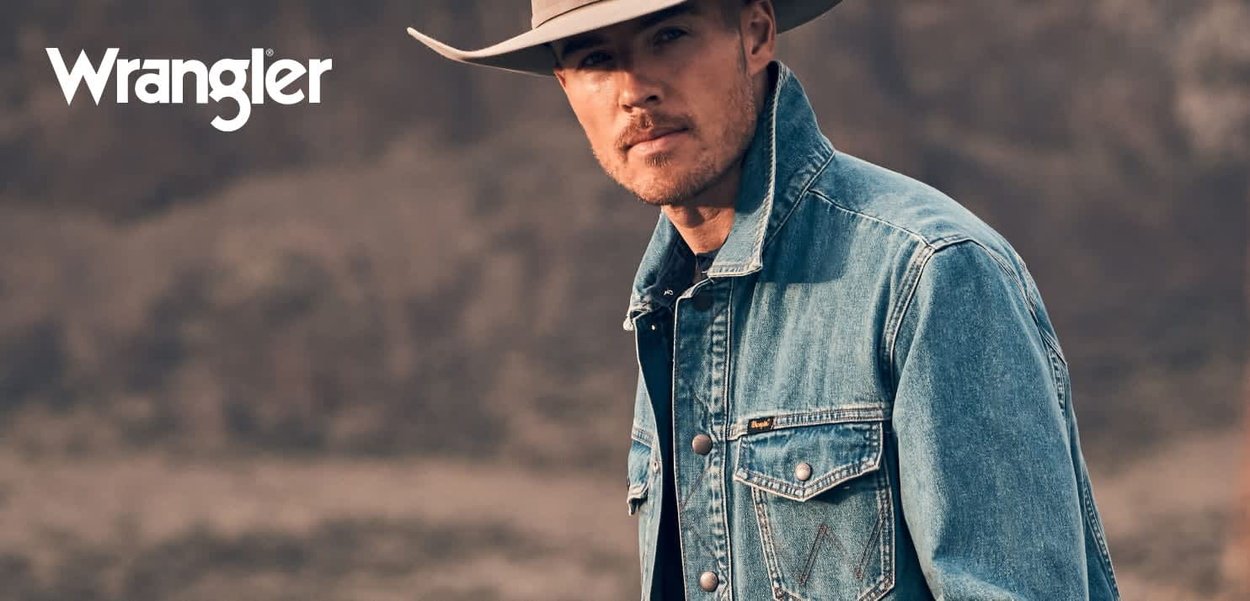 Denimjakke i lys blå med frontlommer, sølvdetaljer og en avslappet passform. Brukes over en svart skjorte, med en grå cowboyhatt.