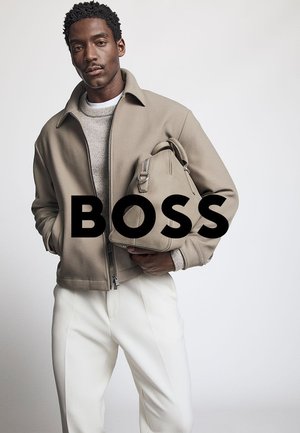 Beige Reißverschlussjacke über einem hellen Pullover, weiße maßgeschneiderte Hose und eine neutrale Handtasche mit Griff. Sauberes, modernes Design und Textur.