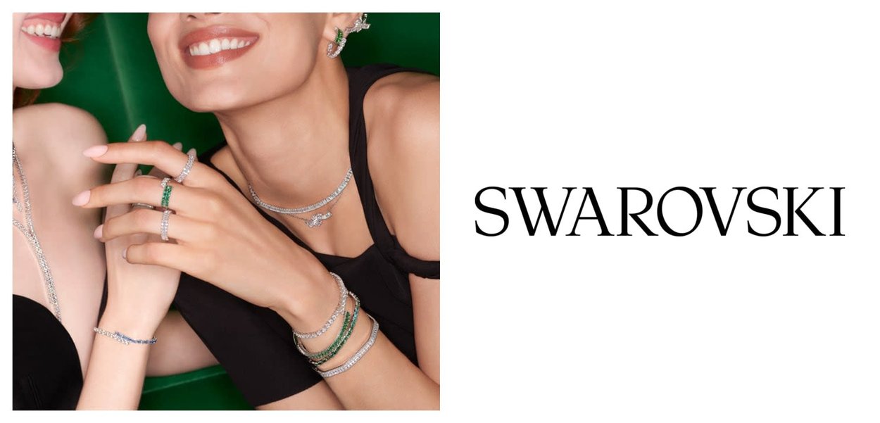 Bijoux Swarovski comprenant des bracelets en argent, des colliers ornés de cristaux clairs et verts, avec des designs élaborés sur un fond vert.
