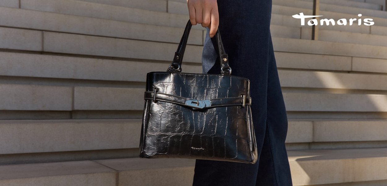 Zwarte faux krokodillenleren handtas met een gestructureerde vorm, zilverkleurige accenten en een afneembare schouderriem. Gladde textuur en minimale details.