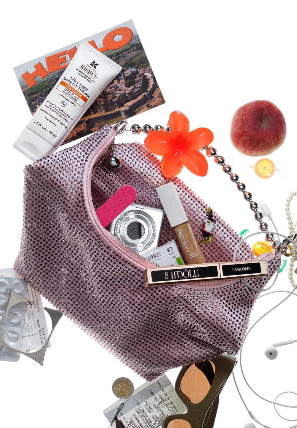 Funkelnde rosa Handtasche mit Strasssteinen. Enthält Hautpflegeprodukte, Kamera, Nagelfeile, Make-up, Süßigkeiten, Sonnenbrille, Münzen und Postkarten.