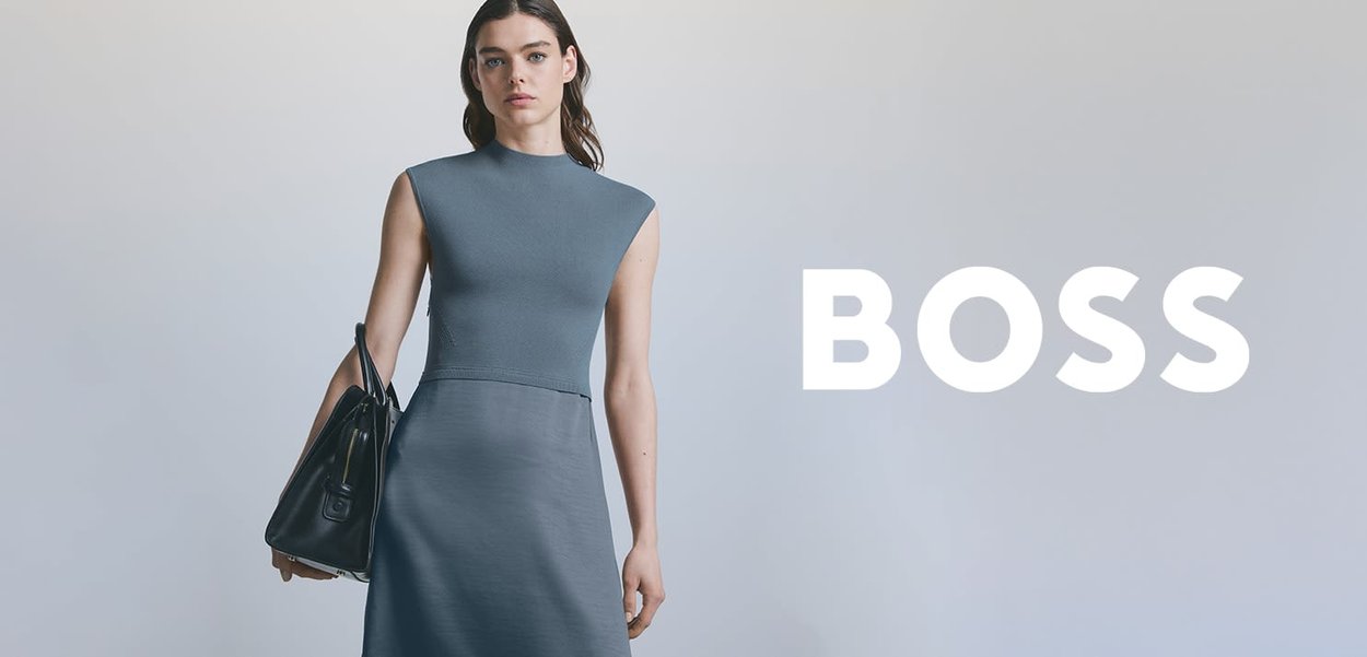 Fitted blue dress with a high neckline and sleeveless design, paired with a black handbag. Smooth fabric and minimalist style.