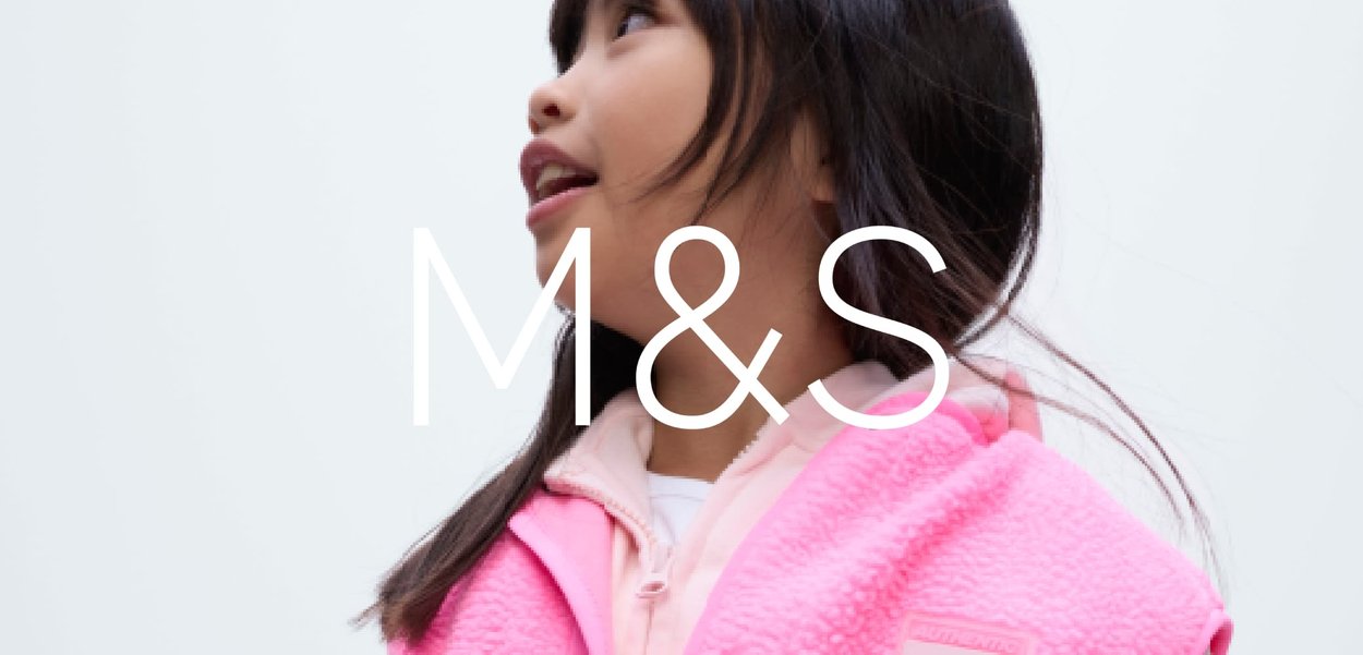 Veste sans manches en polaire rose avec capuche, dotée de deux poches à l'avant et d'une surface texturée. Portée par-dessus une chemise à manches longues de couleur claire.