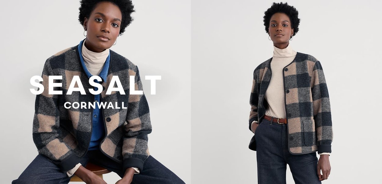 Collared plaid jacket in dark blue, tan, and gray wool, featuring a button closure and two front pockets, paired with a cream turtleneck.