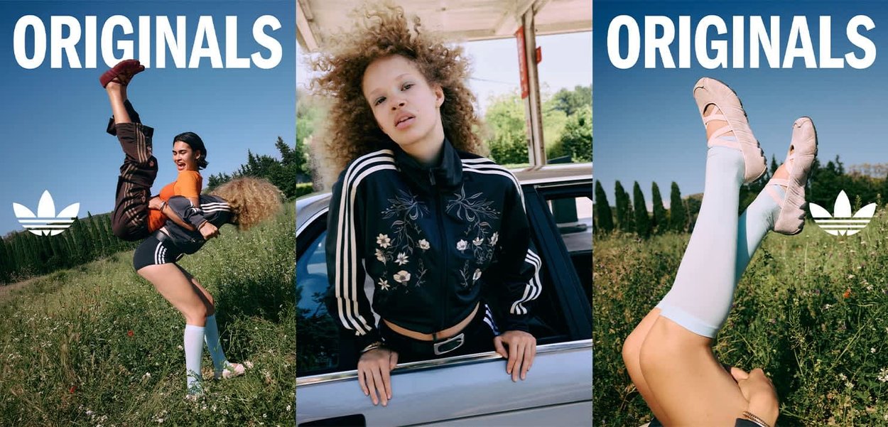Dos mujeres con conjuntos deportivos de Adidas posan al aire libre en un campo y junto a un coche, con una levantando a la otra y zapatos de ballet visibles.