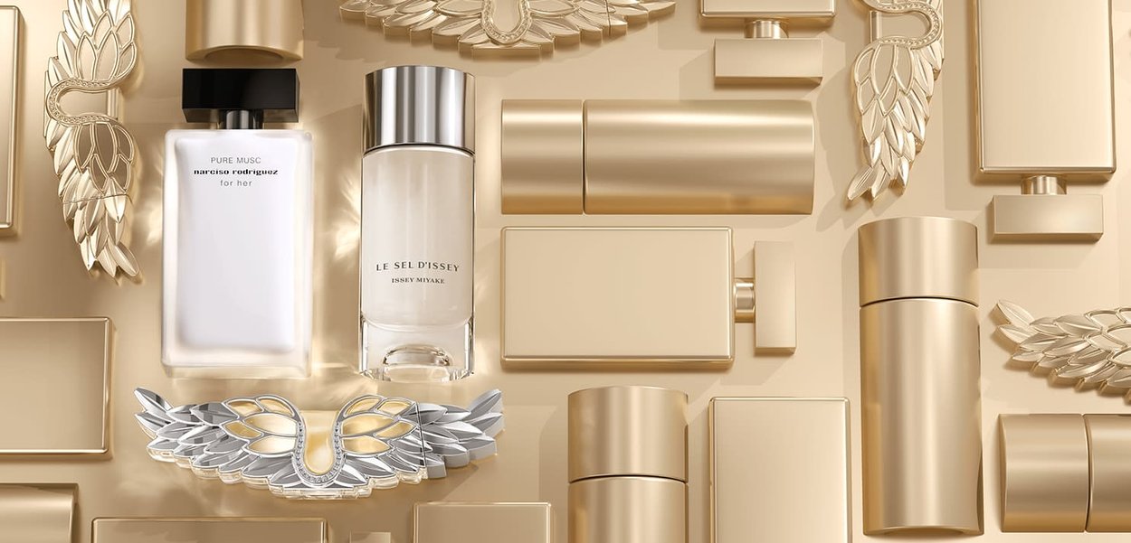 Twee parfumflesjes op een achtergrond met gouden tinten. Eén flesje is rechthoekig met een zwarte dop, het andere is cilindrisch met een zilveren dop. Decoratieve gouden en zilveren accenten omlijsten de flesjes.