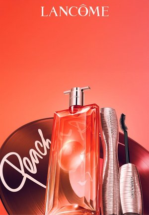 Flacon de parfum Lancôme et mascara Curl Goddess en tons or rose sur fond couleur pêche avec un disque vinyle étiqueté « Peach ».