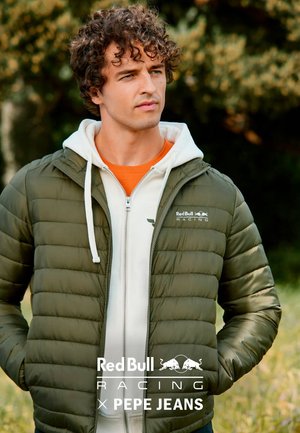 Olijfgroene donzen jas met een rits aan de voorkant, een witte capuchonsweater eronder en een Red Bull Racing-logo op de borst.
