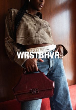 Przycięta brązowa koszula w kratę z zapięciem na guziki, zestawiona z jasnoniebieskimi dżinsami. Bordowa strukturalna torebka z wytłoczonym logo "WB".