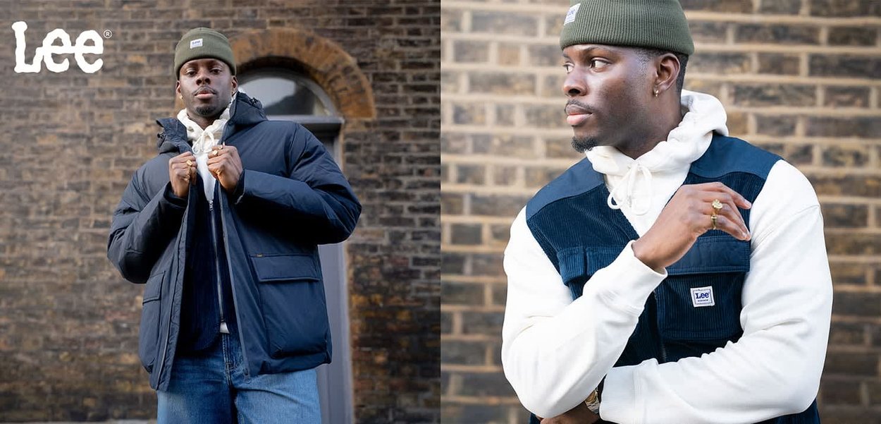 Marinblå puffjacka med dragkedja, kombinerad med en vit hoodie och en manchesterväst med mörkblå detaljer. Bärs med ljusblå jeans.