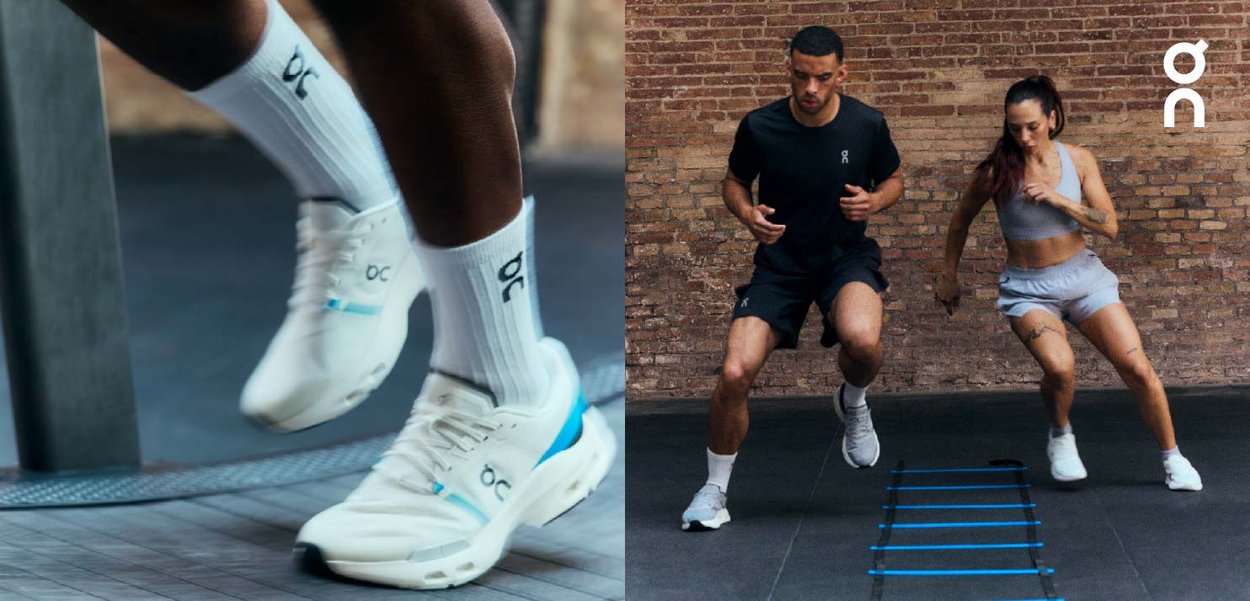 Zapatillas de running en blanco con detalles en azul, con una parte superior de malla y suela acolchada. Dos individuos realizando ejercicios de agilidad en el suelo de un gimnasio.
