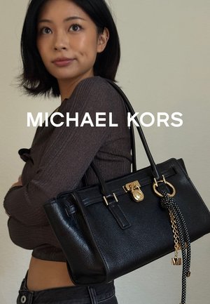 Schwarze Lederhandtasche mit goldenen Beschlägen, hervorgehobenem Schlossakzent und geflochtenem Tragegurt. Elegantes, strukturiertes Design.