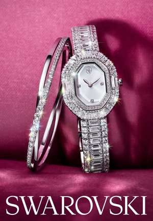 Swarovski-horloge heeft een octagonale zilveren wijzerplaat met diamanten accenten, gecombineerd met een bijpassende armband, alles tegen een textuur roze achtergrond.