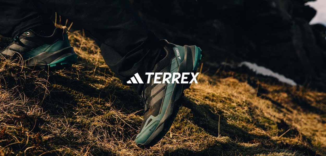 Terrex vandrestøvle med en sort overdel, turkise accenter og en robust sål. Har lagdelt design og synlig snøring.