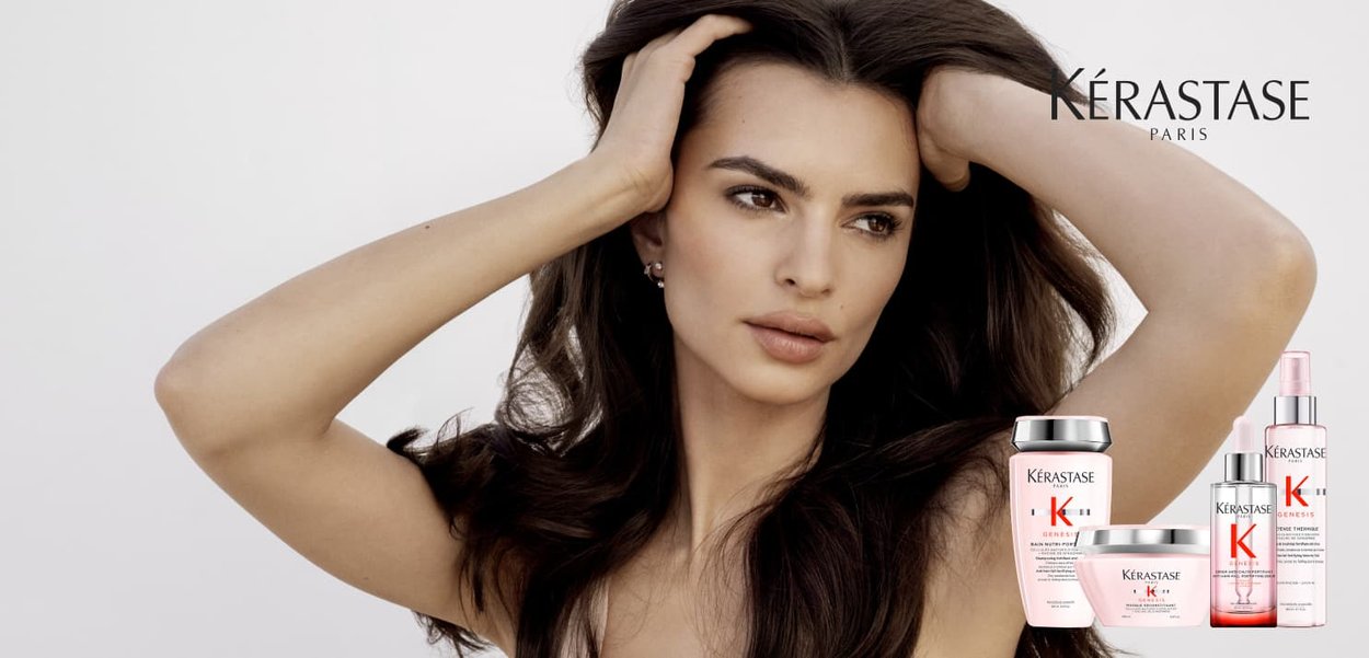 Produits de soin capillaire Kérastase, y compris shampooing et traitements, présentés sur un fond blanc à côté d'un modèle aux cheveux ondulés et foncés.