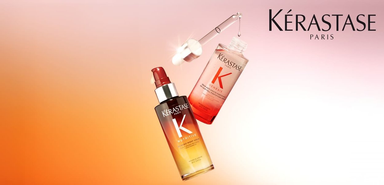 Siero per capelli Kérastase in una bottiglia ambrata scura con liquido rosso, dotato di contagocce. Sfondo rosa sfumato, design pulito e moderno.
