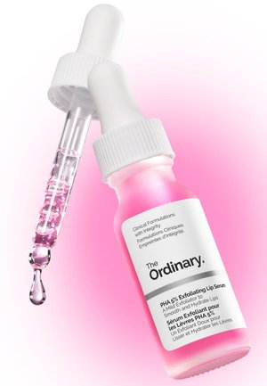Flacon compte-gouttes teinté de rose étiqueté The Ordinary PHA 5% Exfoliating Lip Serum avec un compte-gouttes libérant une goutte de liquide rose.