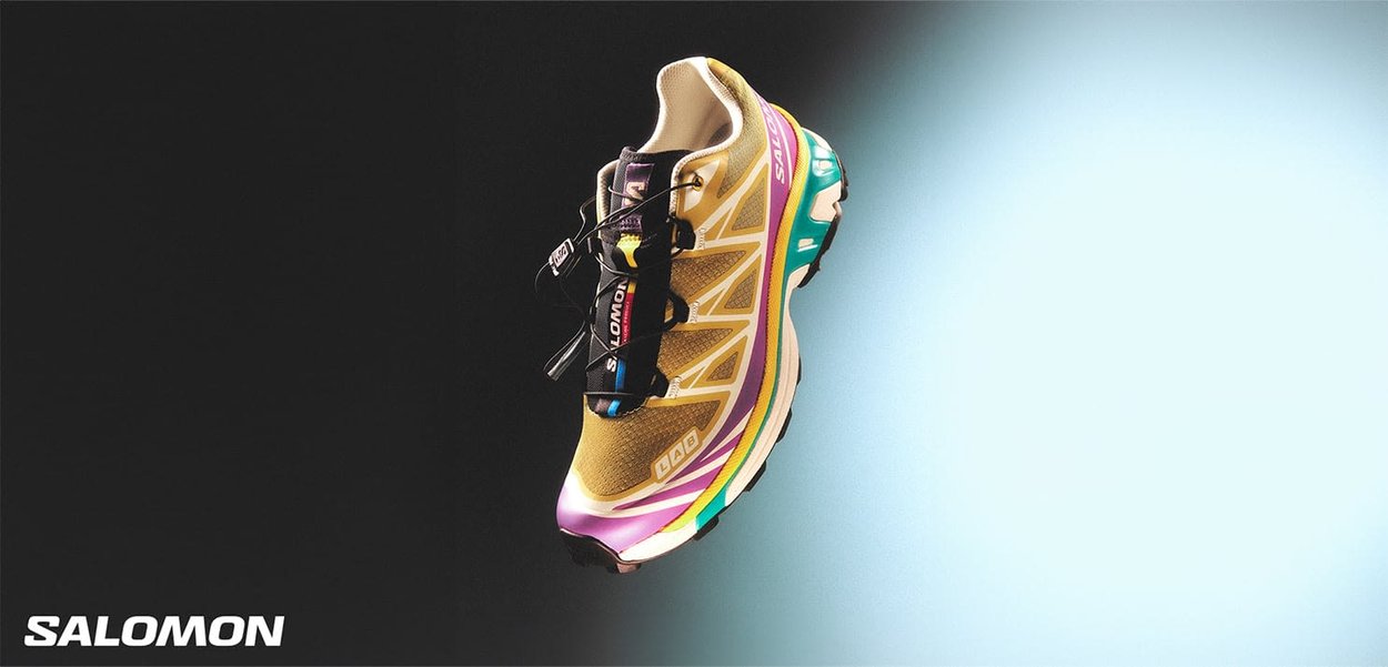 Chaussure de course Salomon avec une tige en mesh, des accents jaunes et violets, design respirant et semelle texturée pour l'adhérence. Équipée d'un système Quicklace.