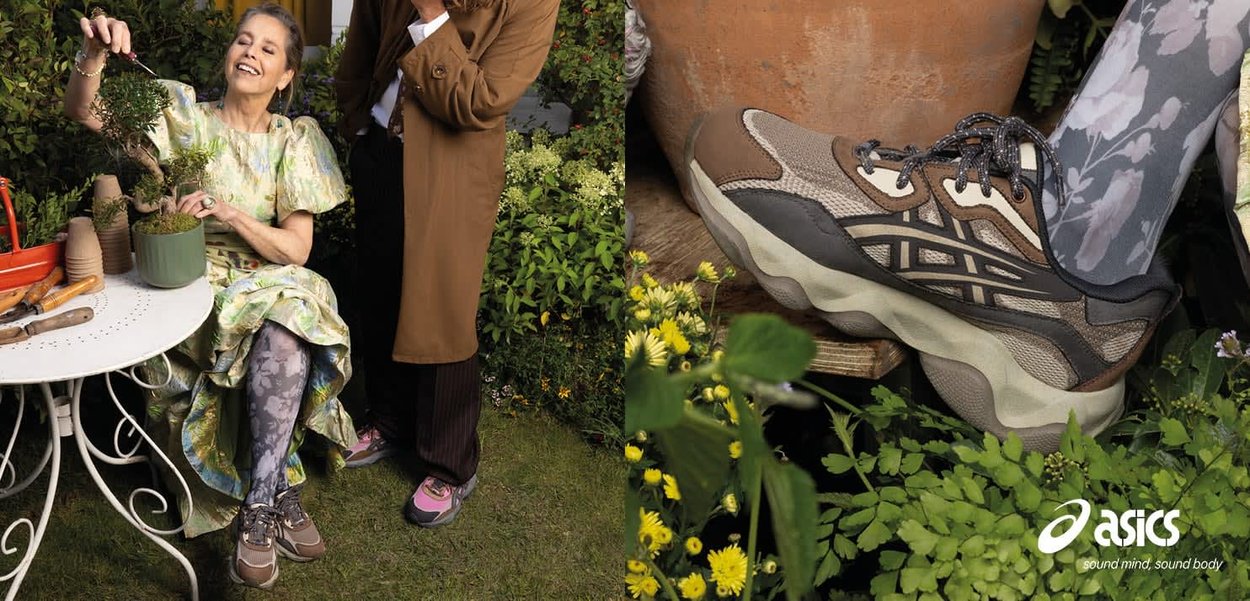 Mujer con vestido estampado y zapatillas cuidando plantas al aire libre, con otra persona de pie cerca en un entorno de jardín.