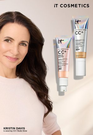 Lächelnde Frau mit langen dunklen Haaren neben zwei Tuben der iT Cosmetics CC+ Farbkorrektur-Sonnencreme mit den Aufschriften Nude Glow LSF 40 und LSF 50+.