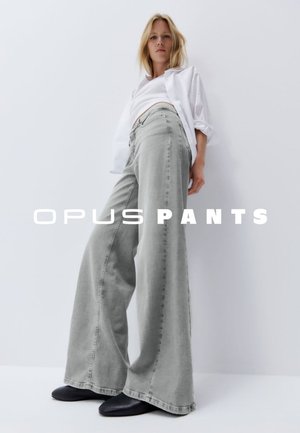 Wide-leg gray denim pants with a high waist and subtle texture, paired with a fitted white top and black footwear.