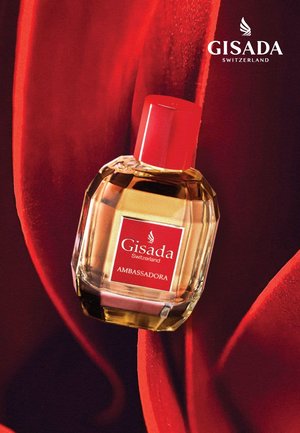 Gisada Ambassadora parfum in een helder glazen flesje met een rode dop, voorzien van een vierkant etiket met witte tekst op een donkerrode achtergrond.