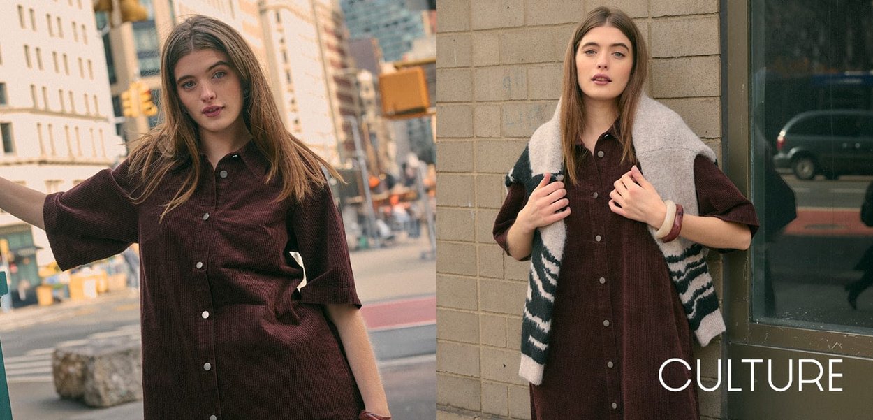 Abito camicia in corduroy marrone con maniche corte e bottoni frontali, abbinato a un cardigan spesso grigio e nero con motivi.