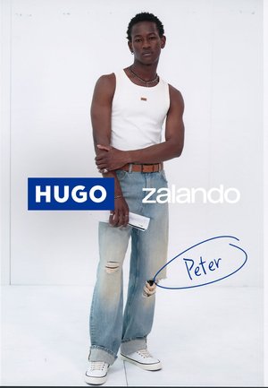Weisses Tanktop, hellblaue, ausgefranste Jeans und weisse Sneakers. Zu den Accessoires gehören ein Gürtel und geschichtete Armbänder. Markenlogos sind sichtbar.