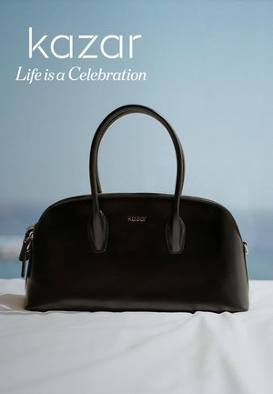 Borsa a mano in pelle nera con due manici arrotondati, chiusura con zip e logo discreto. Texture liscia e forma strutturata, su uno sfondo chiaro.