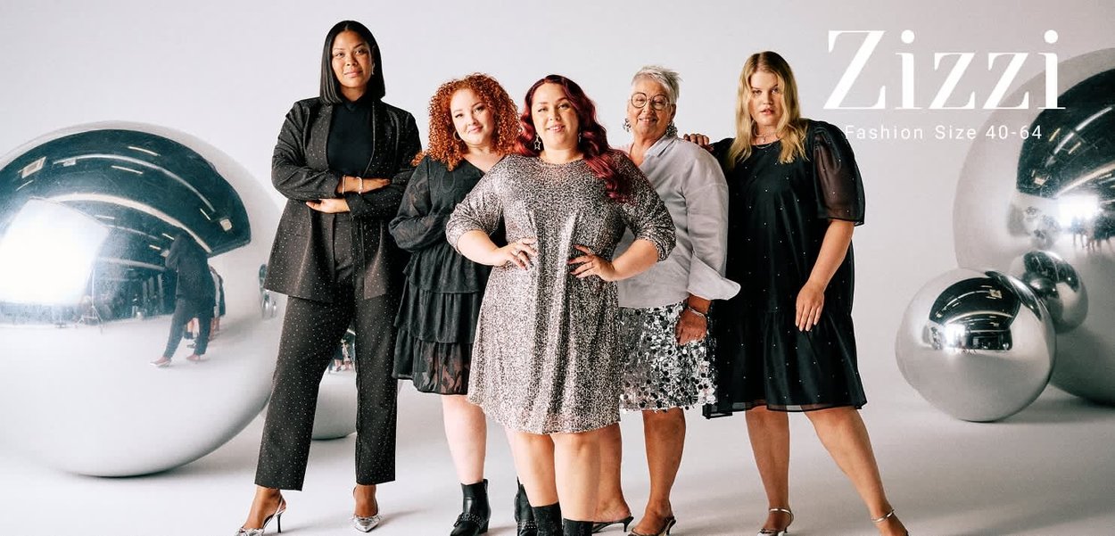 Five women stand together wearing diverse outfits: black textured suit, sparkly silver dress, ruffled black dress, white blouse, and patterned skirt.