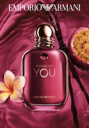 Flacon de parfum violet brillant Emporio Armani « Power of You » entouré d'une fleur, de gousses de vanille et d'un fruit de la passion sur un fond violet soyeux.