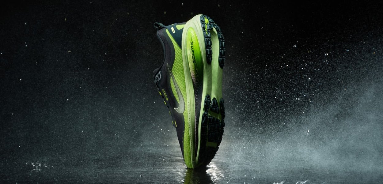 Zapatilla de running con un diseño en negro y verde neón, parte superior ligera, malla texturizada y suela de goma con patrón para tracción.