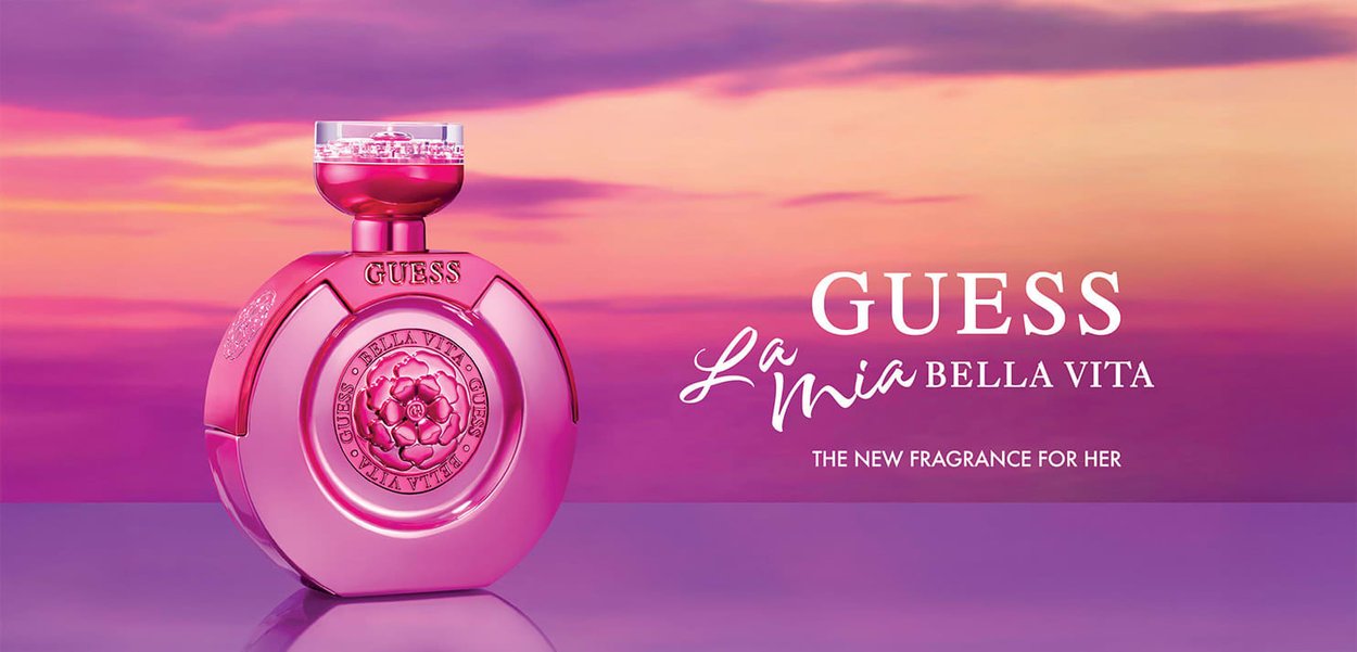 Rosa Glasparfümflasche mit abgerundeter Form, vorne mit floralem Design und transparentem Verschluss. Markenlogo ist sichtbar.