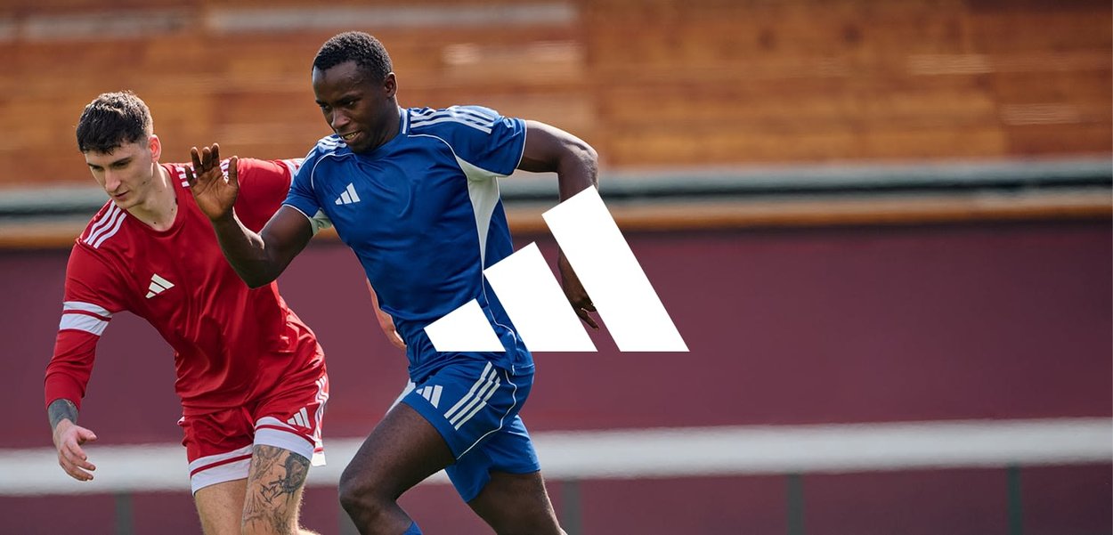 Des maillots de sport bleus et rouges avec des accents blancs, dotés de manches courtes et d'un design sportif, portés par des joueurs sur un terrain.