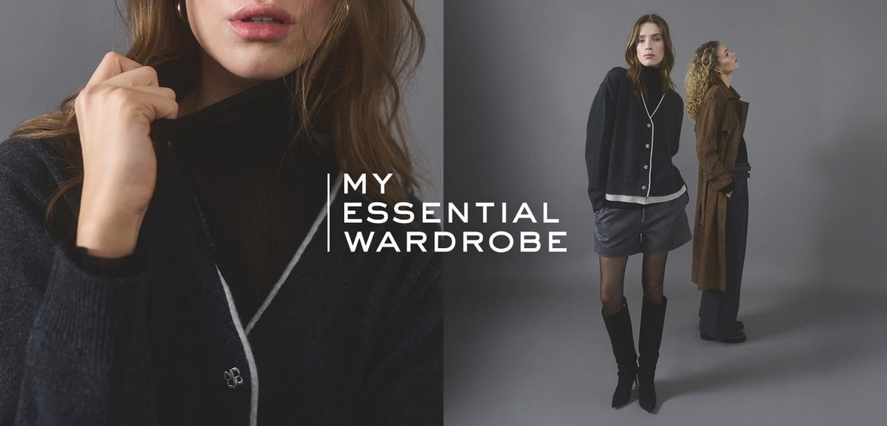 Schwarzer Strickcardigan mit weißem Besatz, kombiniert mit grauen Shorts und schwarzen kniehohen Stiefeln. Ein Model trägt einen braunen Mantel neben ihr.