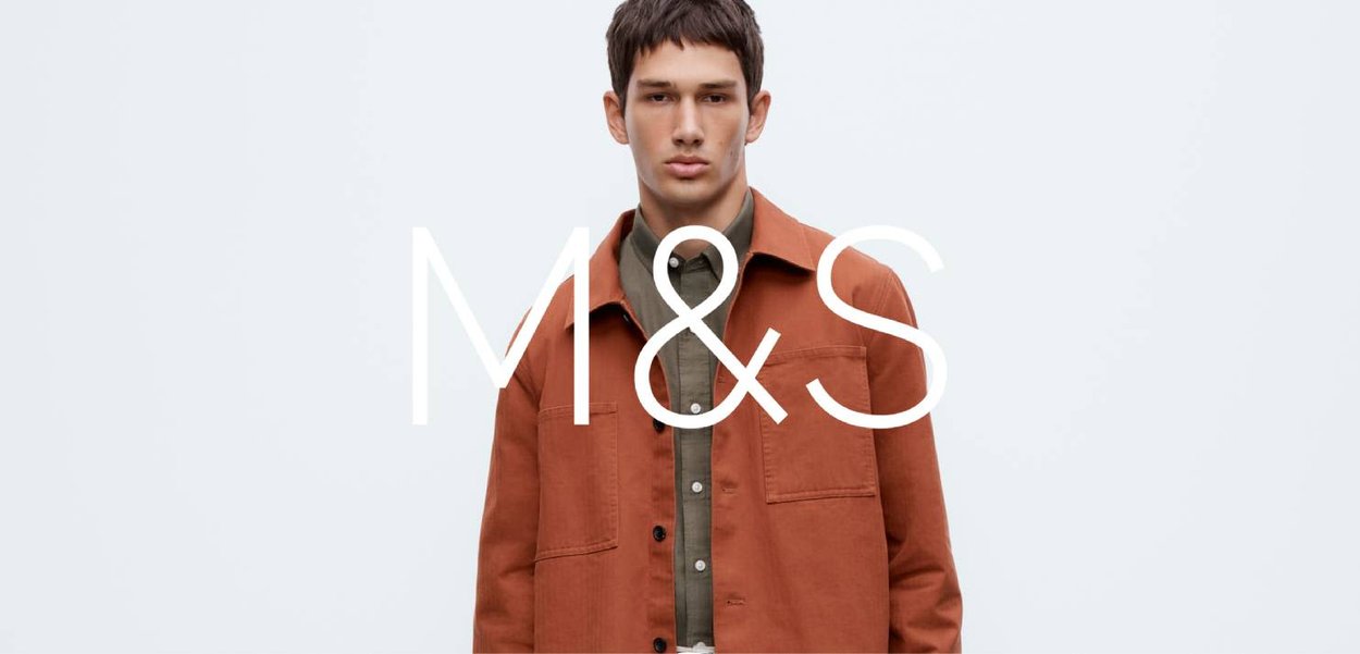 Veste orange rouille à boutons, avec deux poches avant, portée sur une chemise verte, sur fond blanc uni.