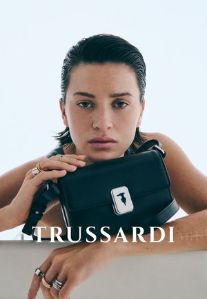 Borsa a mano in pelle nera con chiusura in metallo argentato, forma rettangolare, texture liscia e dettaglio logo sulla parte anteriore.