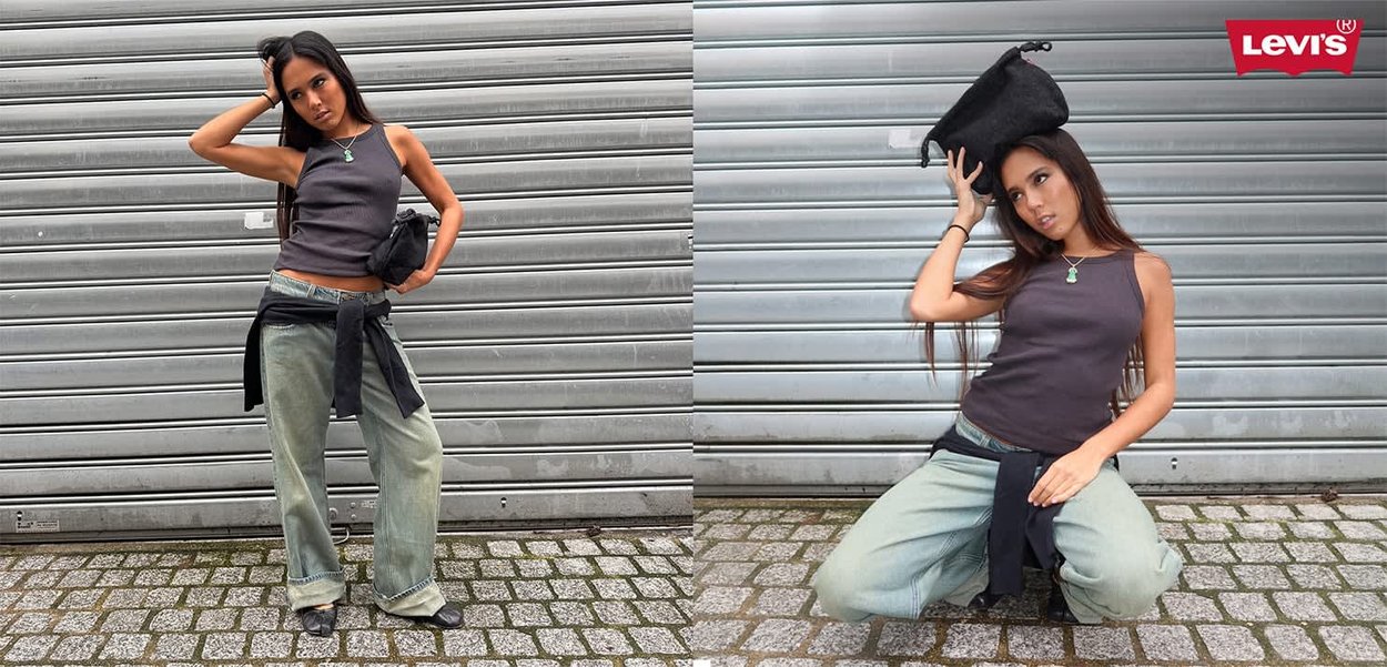 Femme portant un débardeur gris et un jean ample posant devant un volet métallique, tenant un sac noir sur la tête dans la deuxième pose.