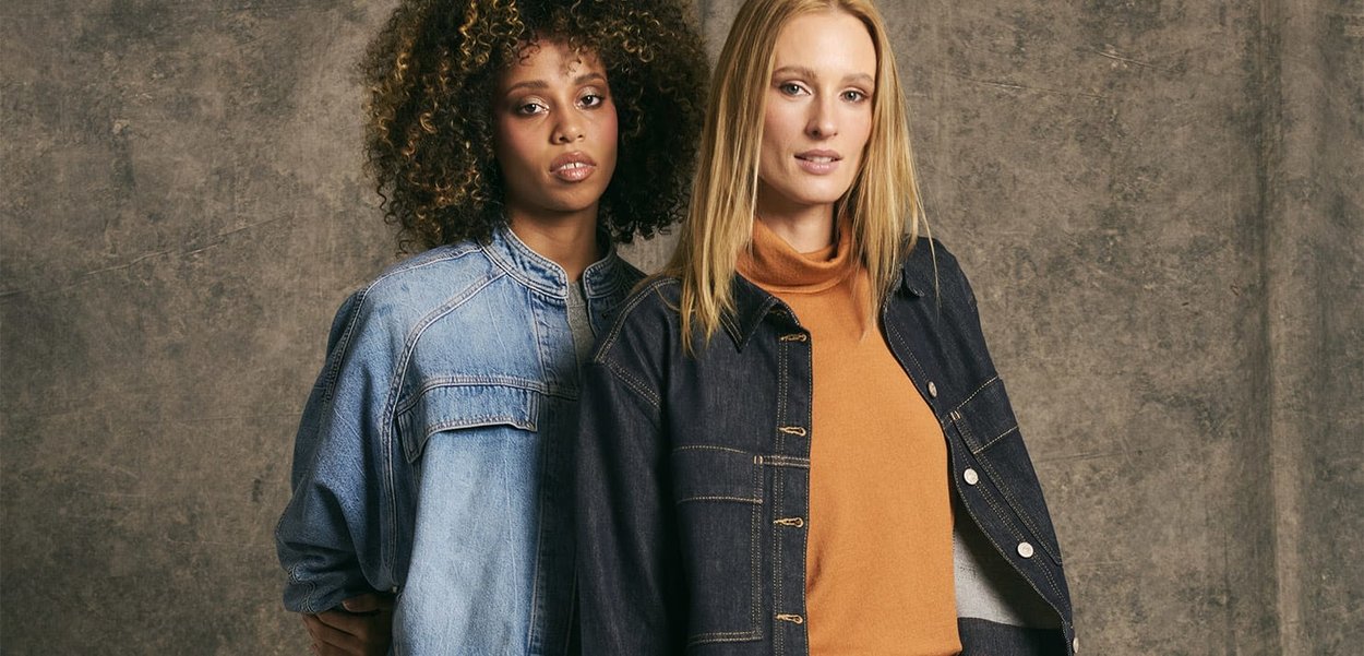 Denim jackets in light and dark blue on two models. One wears an orange turtleneck, the other has a gray top underneath the jacket.