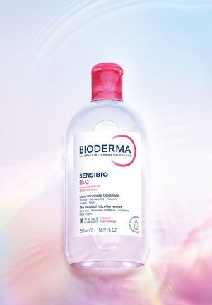 Klare Plastikflasche Bioderma Sensibio H2O Mizellenwasser mit rotem Verschluss, für empfindliche Haut, 500 ml, vor weichem Farbverlauf im Hintergrund.