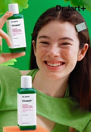 Deux bouteilles vertes de lotion de traitement réparateur intensif apaisant Dr. Jart+ Cicapair, l'une tenue dans une main, avec des bouchons blancs et des étiquettes transparentes.