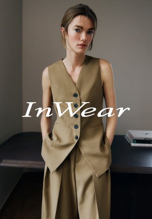 Sakko ohne Ärmel in Braun mit V-Ausschnitt, Vorderknopfverschluss, zwei seitlichen Taschen und lockeren, hochtaillierten Hosen. Einfaches, minimalistisches Design.