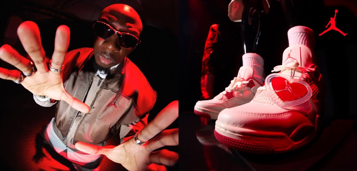 Mężczyzna w okularach przeciwsłonecznych i pierścieniach sięga rękami w stronę kamery; zbliżenie na białe sneakersy Air Jordan z zawieszką w kształcie serca na prawej stopie.